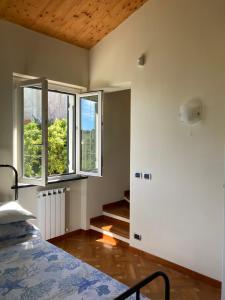 une chambre vide avec un lit et deux fenêtres dans l'établissement Casa Margherita parking, à Zoagli