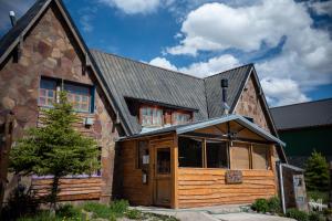 a large wooden house with a gambrel roof at Hebes House Hostal in Caviahue