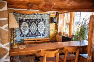 a dining room with a table and chairs and a rug at Hebes House Hostal in Caviahue