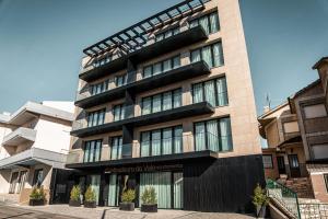 a tall building with windows and plants in front of it at Miradouro do Vale - Apartamentos in Fátima
