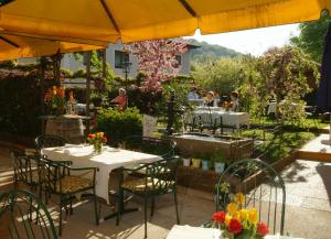 a restaurant with tables and chairs under an umbrella at Landgasthof zur Linde Laaben in Laaben