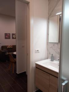 DONNA MELA apartments في بارشلونا-بوتسو دي غوتو: حمام مع حوض أبيض ومرآة