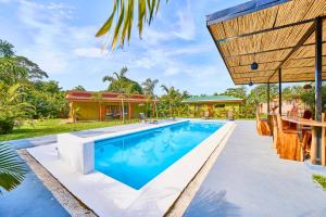 an image of a swimming pool in front of a house at Villas Ande in Puerto Viejo