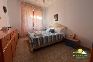 a bedroom with a bed with a dresser and a dresser at Pratoranieri - Sparviero in Follonica