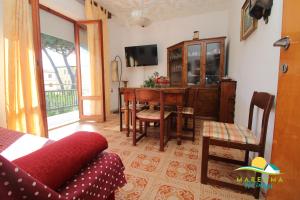 a living room with a red couch and a table at Pratoranieri - Sparviero in Follonica