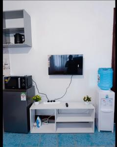 una cucina con lavandino e una TV a parete di Malaika Diani Homes a Ukunda