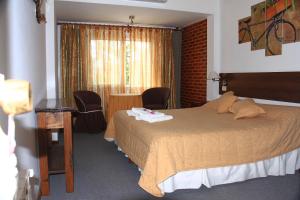a hotel room with a bed and a window at Hostería Anchimalen in Villa Gesell