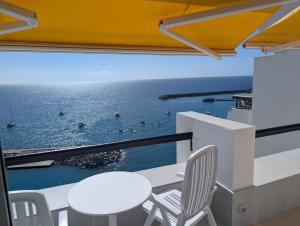 un comedor blanco con vistas al océano en Sonido del mar Gran Canaria - Montemarina - luxury panoramic view, en Mogán