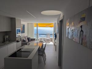 a kitchen and living room with a view of the ocean at Sonido del mar Gran Canaria - Montemarina - luxury panoramic view in Mogán