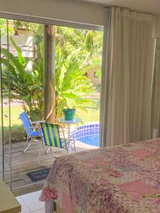a bedroom with a bed and a patio with a table and chairs at Quarto e sala com piscina em Maceió - Villas Tulipa 02 in Maceió +13 photos