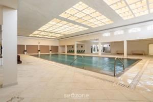 a swimming pool in a large building with a skylight at Lindo Condomínio com Lazer em Poços de Caldas - QUI in Poços de Caldas +41 photos