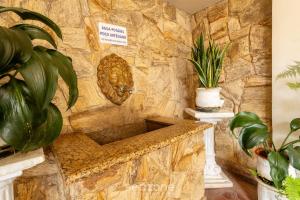 a stone bathroom with a stone wall with plants at Lindo Condomínio com Lazer em Poços de Caldas - QUI in Poços de Caldas