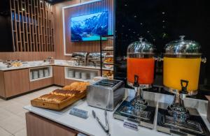 a buffet with two glasses of juice and bread at Holiday Inn Rosario by IHG in Rosario