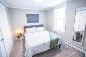 a white bedroom with a bed and a window at Peaceful Home in Heart of Oshkosh in Oshkosh +13 photos