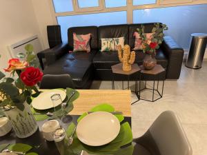 a living room with a black leather couch and a table at Le Nid d'Ange in Vierzon