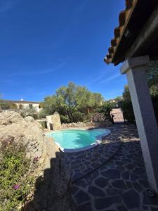 a small pool with a stone walkway next to a house at Bellissima villa piscina 8 pax 1500 mt dal mare FMP-CAT01-PI in Monte Petrosu
