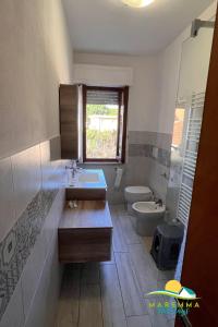 a bathroom with a sink and a toilet and a window at Pratoranieri - Sparviero in Follonica +21 photos