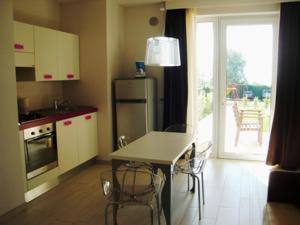 a kitchen with a table and a refrigerator at La Fattoria Apartments in Lazise