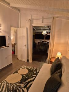 una sala de estar con un sofá y una mesa en Villa CANNELLE Pointe Batterie, piscine, vue mer, en Deshaies
