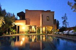 a house with a swimming pool in front of a house at Atmosphérique Paradise in Tamraght Ouzdar