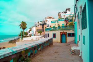 a group of buildings on a hill with the ocean at Atmosphérique Paradise in Tamraght Ouzdar