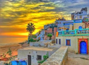 a group of buildings on the beach at sunset at Atmosphérique Paradise in Tamraght Ouzdar