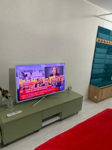 a flat screen tv sitting on a table in a living room at Slatina Armoniei central Luxury Studio Oferim transport de la aeroport și retur contra cost in Slatina