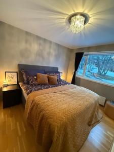 ein Schlafzimmer mit einem großen Bett und einem Kronleuchter in der Unterkunft Spacious 3 bed terraced house in Trondheim