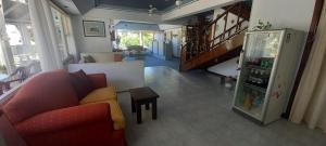 a living room with a red couch and a refrigerator at Hostería Anchimalen in Villa Gesell