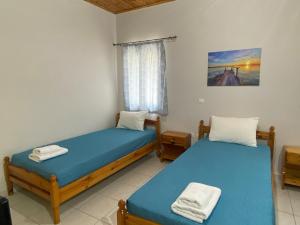 a bedroom with two beds and a window at Nefeli House in Loutsa