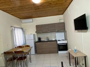 a kitchen with a table and a kitchen with a sink at Nefeli House in Loutsa +3 photos