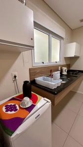 a kitchen with a sink and a counter top at Apto Top Centrum Holambra/excelente localização in Holambra