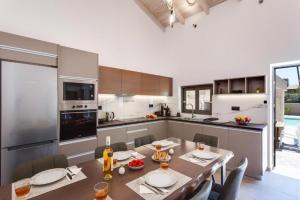 a kitchen with a table and chairs and a table and a kitchen with at Villa Archontiki in Kalamítsion Alexándrou
