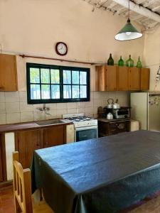 Una cocina con una mesa y un reloj en la pared. en Chacra del Molino, en Navarro