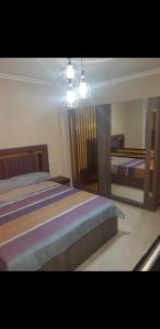 a bedroom with two beds and a chandelier at Appartement 3 meublé équipé in Nador