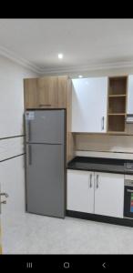 a kitchen with white cabinets and a refrigerator at Appartement 3 meublé équipé in Nador