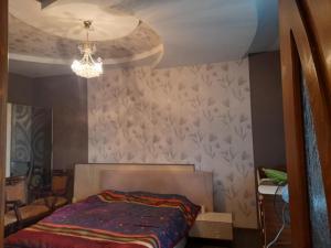 a bedroom with a bed and a chandelier at частный дом in Kutaisi