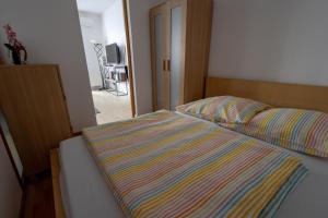 - un lit avec une couette rayée dans une chambre dans l'établissement Praha 2, à Prague