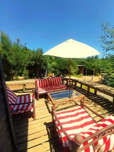 una terraza con sillas, una mesa y una sombrilla en Refugio Silvestre Parque Nacional Siete Tazas-Salida a río y pesca, en El Bolsico 110 fotos más