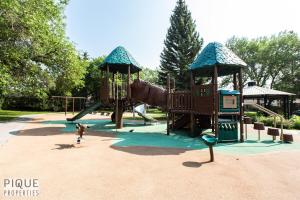 a child is playing on a playground in a park at Park Life Escape-King Beds-Sleeps 10-Pet Friendly in Edmonton