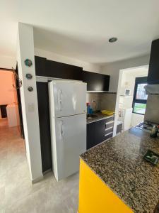 a kitchen with a white refrigerator and a counter at Departamento Ayacucho in Viedma