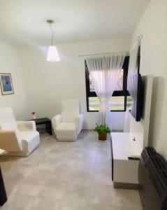 a living room with white furniture and a window at Departamento Ayacucho in Viedma