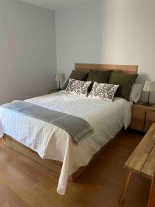 a bedroom with a large white bed with pillows at Apartamento Villanua centro in Villanúa