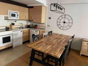a kitchen with a wooden table and chairs in a kitchen at Apartamento Villanua centro in Villanúa