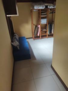 Zimmer mit blauem Sofa und Regal in der Unterkunft Chalé 2 in Nova Friburgo