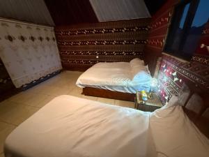 a room with two beds and a tv in it at Khazali Mountain Camp in Wadi Rum +16 photos