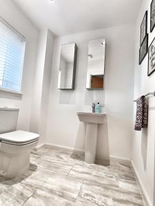 a bathroom with a toilet and a sink and mirrors at 4 miles to Westhill by Lains Lettings in Aberdeen