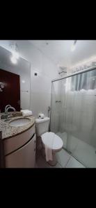 a bathroom with a shower and a toilet and a sink at Apartamento próximo à praia de taperapuã in Porto Seguro