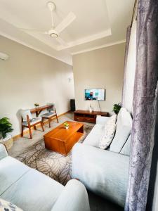 ein Wohnzimmer mit zwei weißen Sofas und einem Tisch in der Unterkunft Nana Apartment in Marombosa