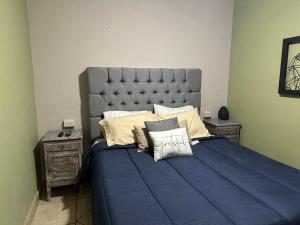 a bedroom with a large blue bed with pillows at Casa 86 in San Miguel de Allende